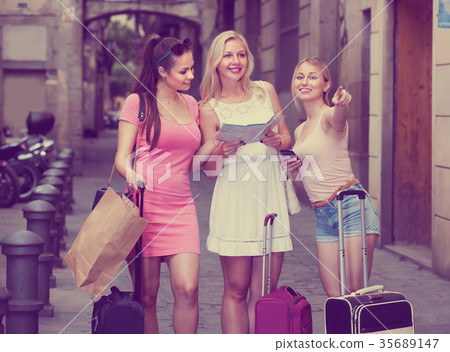 three traveling girls with paper map . three traveling girls with paper map . 35689147