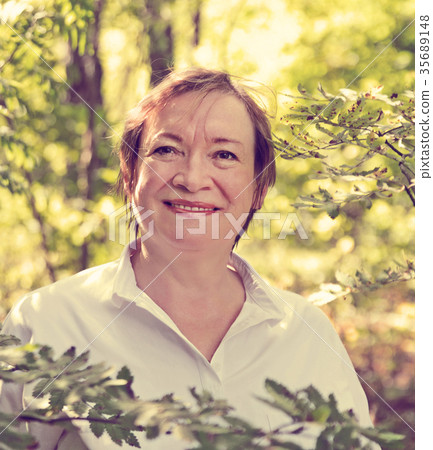 Woman standing in summer in wood Woman standing in summer in wood 35689148