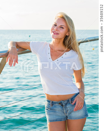 Cheerful female is posing playfully on pirce in her free time Cheerful female is posing playfully on pirce in her free time 35689152