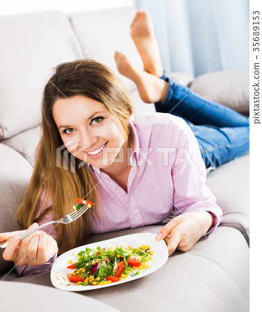 Girl eating green salad Girl eating green salad 35689153