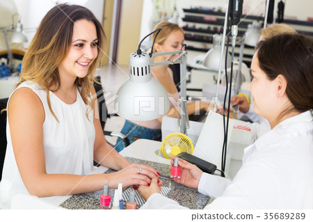 Female clients doing nails in nail salon in afternoon 35689289