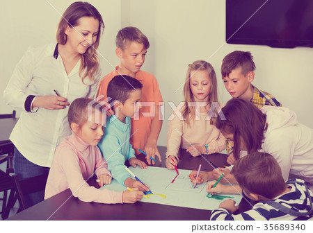 Children with teacher drawing together in classroom 35689340