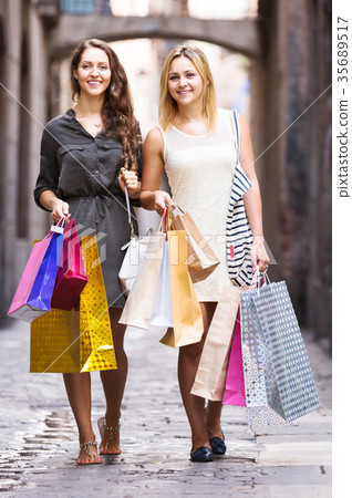girls carrying bags with purchases 35689517