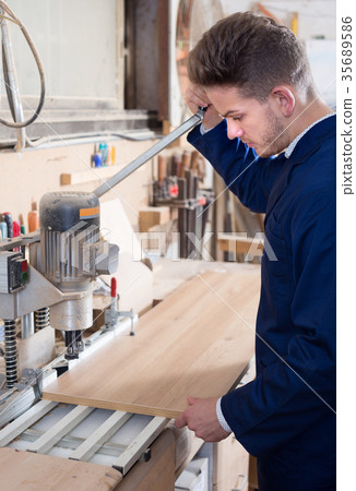 Male joiner adjusting chipboard at workshop 35689586