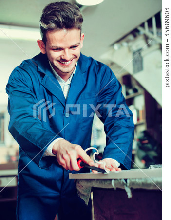 Working man practising his skills in plank chiseling 35689603