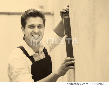 builder posing with spirit level 35689612