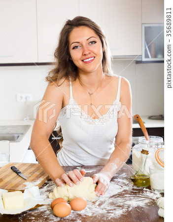 Happy woman preparing dough Happy woman preparing dough 35689811