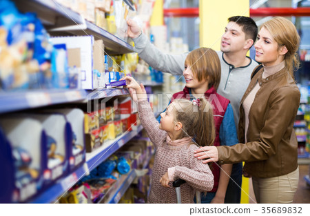 Parents with two kids choosing crispy flakes in shop Parents with two kids choosing crispy flakes in shop 35689832
