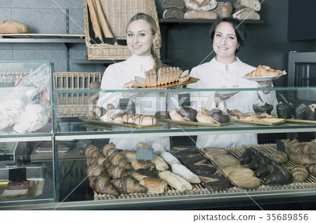 Agreeable woman and young girl suggesting pastry Agreeable woman and young girl suggesting pastry 35689856
