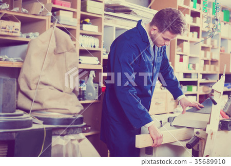 Man processing plank at workshop 35689910