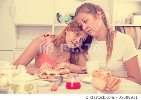 Female talking with young sad friend at home 35689911