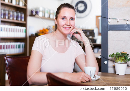 young woman resting alone in cafe and drinking coffee 35689930