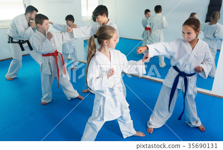 Glad kids sparring in pairs in karate class Glad kids sparring in pairs in karate class 35690131