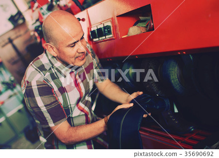 Professional diligent craftsman polishing footwear 35690692