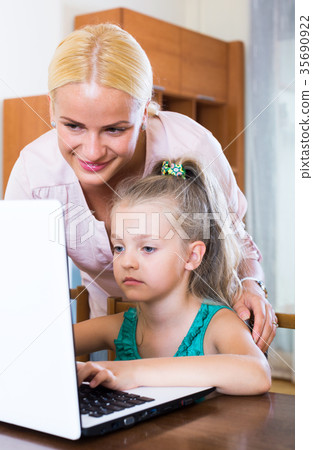 Happy mother teaching little daughter 35690922