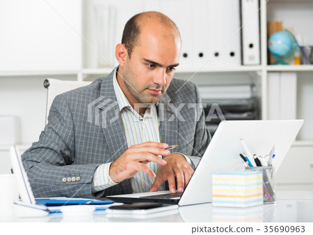 Businessman in office clothes filling up documents 35690963
