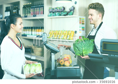 Man seller helping customer to weigh purchases 35691016