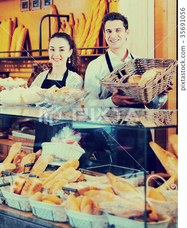 Portrait of friendly couple at bakery display with pastry Portrait of friendly couple at bakery display with pastry 35691056