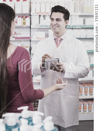 pharmacist serving woman in pharmacy pharmacist serving woman in pharmacy 35691151