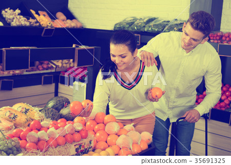 Couple choosing fruits in shop Couple choosing fruits in shop 35691325