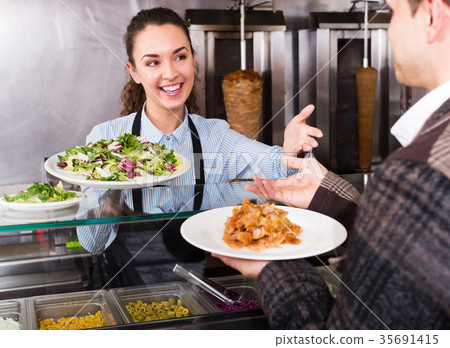 Girl and satisfied customer buying kebab 35691415