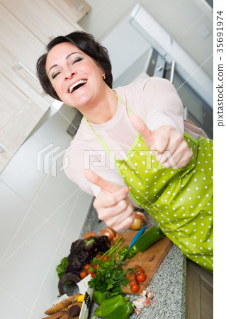 Portrait of cooking brunette housewife in apron 35691974