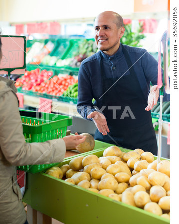 man serving customer purchasing potatoes 35692056