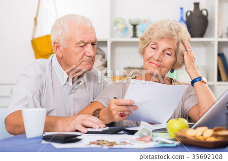 Upset retired couple calculating domestic finances 35692108