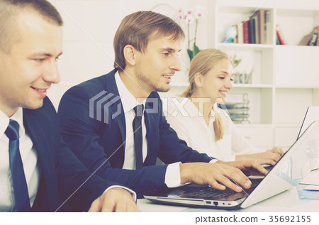 Cheerful business male sitting with coworkers 35692155
