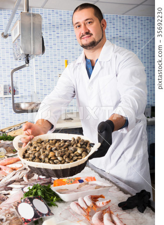 Man holds small basket of mussels Man holds small basket of mussels 35692230