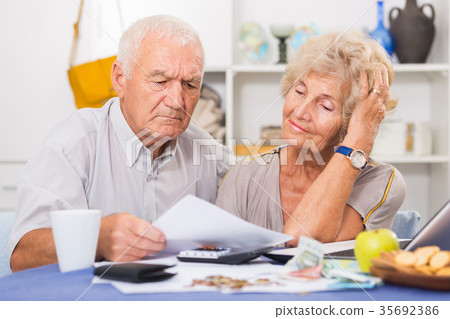 Upset retired couple calculating domestic finances Upset retired couple calculating domestic finances 35692386