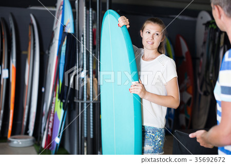 Smilling woman who is choosing surfboard Smilling woman who is choosing surfboard 35692672