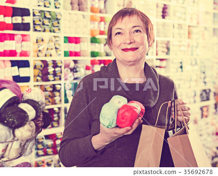 Woman holding shopping bags and accessories for knitting and embroidery Woman holding shopping bags and accessories for knitting and embroidery 35692678