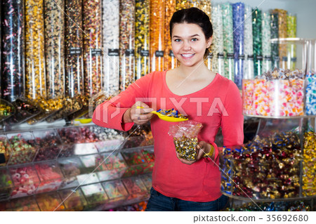 Girl choosing sweets in shop Girl choosing sweets in shop 35692680