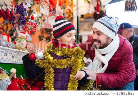 Little girl with dad buying decorations for Xmas Little girl with dad buying decorations for Xmas 35692682