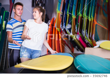 couple is choosing surfboard in nautical shop. 35692746