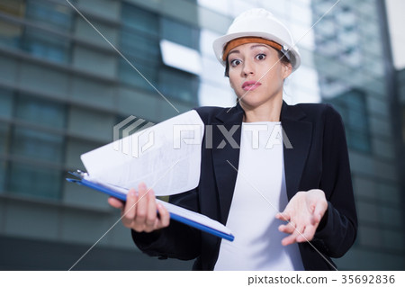 Female engineer in suit and hat with folder is dissatisfieded of documents with project Female engineer in suit and hat with folder is dissatisfieded of documents with project 35692836
