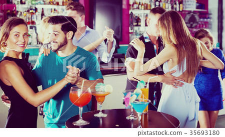 Young women with men are dancing in pairs in the nightclub Young women with men are dancing in pairs in the nightclub 35693180