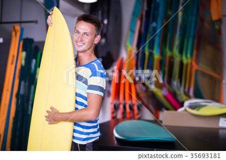 Portrait of smiling guy who is buying surfboard Portrait of smiling guy who is buying surfboard 35693181