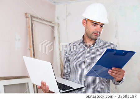 Man is standing with laptop and folder with documents Man is standing with laptop and folder with documents 35693187