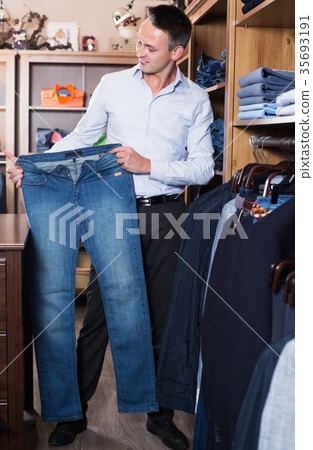 Customer examining trousers Customer examining trousers 35693191