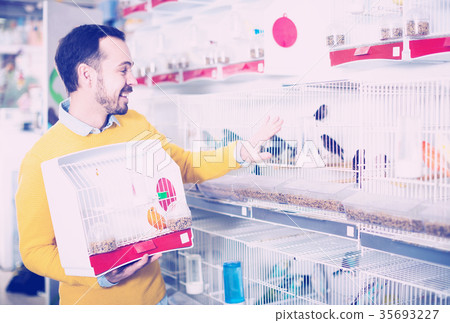 Smiling man choosing pretty bird Smiling man choosing pretty bird 35693227
