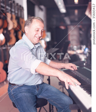 Adult man is playing on music keyboard Adult man is playing on music keyboard 35693417