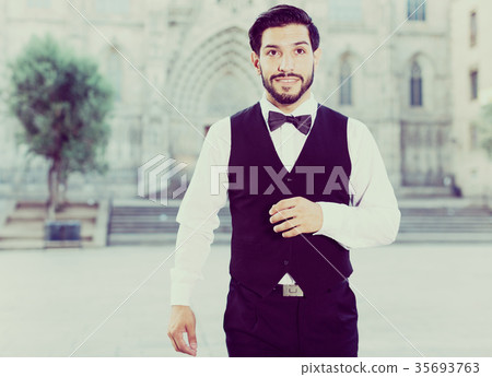 Stylish man in bow tie against cathedral Stylish man in bow tie against cathedral 35693763