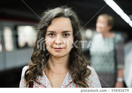 Woman commuter waiting train on public transport station Woman commuter waiting train on public transport station 35693874