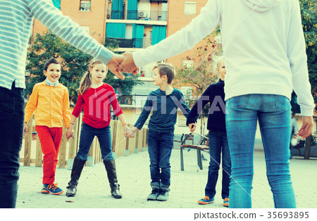 Group of cheerful children playing red rover Group of cheerful children playing red rover 35693895