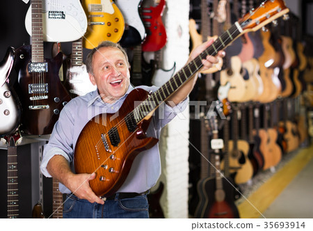 Man choosing electric guitar Man choosing electric guitar 35693914
