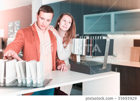 family couple looking at kitchen tabletop in furniture workshop family couple looking at kitchen tabletop in furniture workshop 35693929