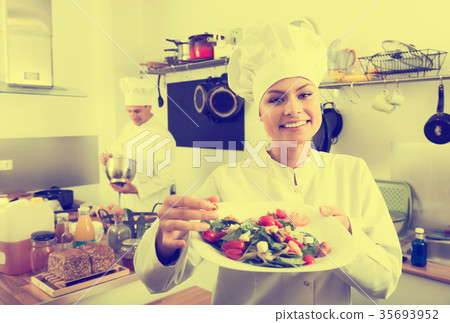 Female young cook holding plate 35693952