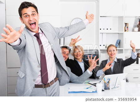Smiling businessman and team delighted with achievements 35693954